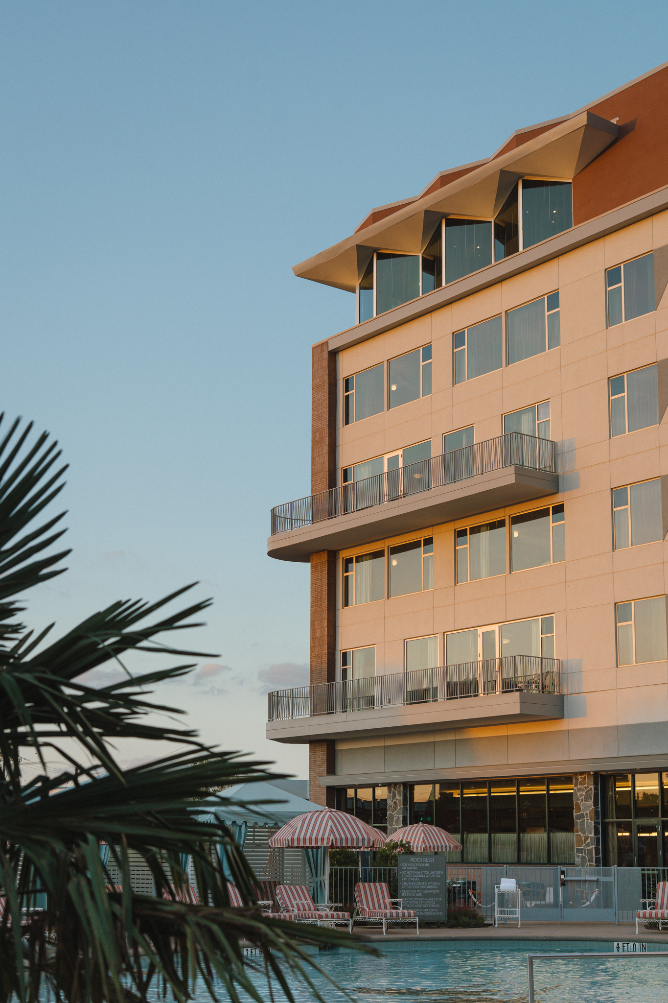 a building with umbrellas and palm trees